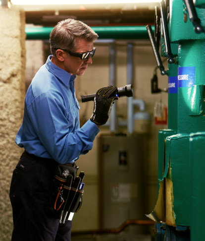 An ABM expert inspecting critical building equipment