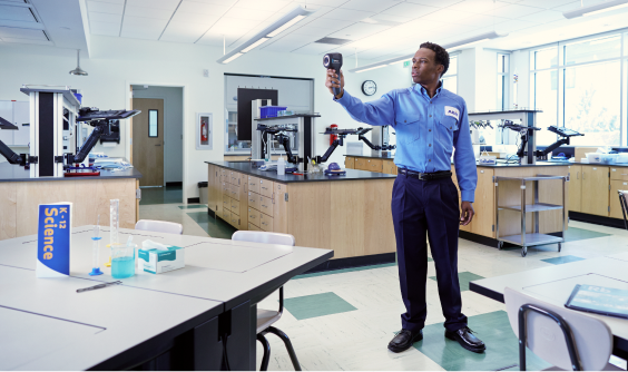 An ABM expert measuring indoor air quality in a classroom