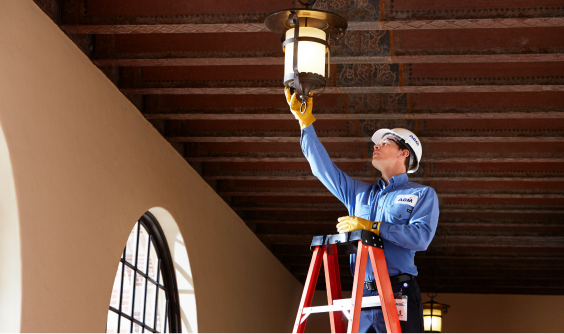 An ABM expert inspecting facility lighting