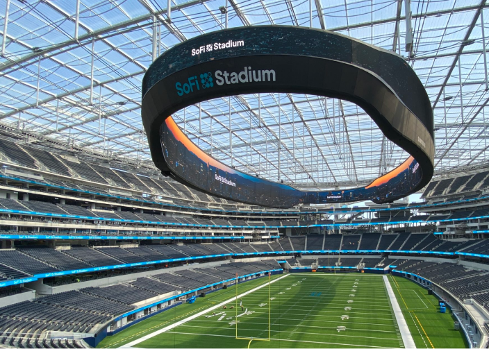 Interior of SoFi Stadium showcasing the seating, football field, clear roof and 360-degree ring screen. 